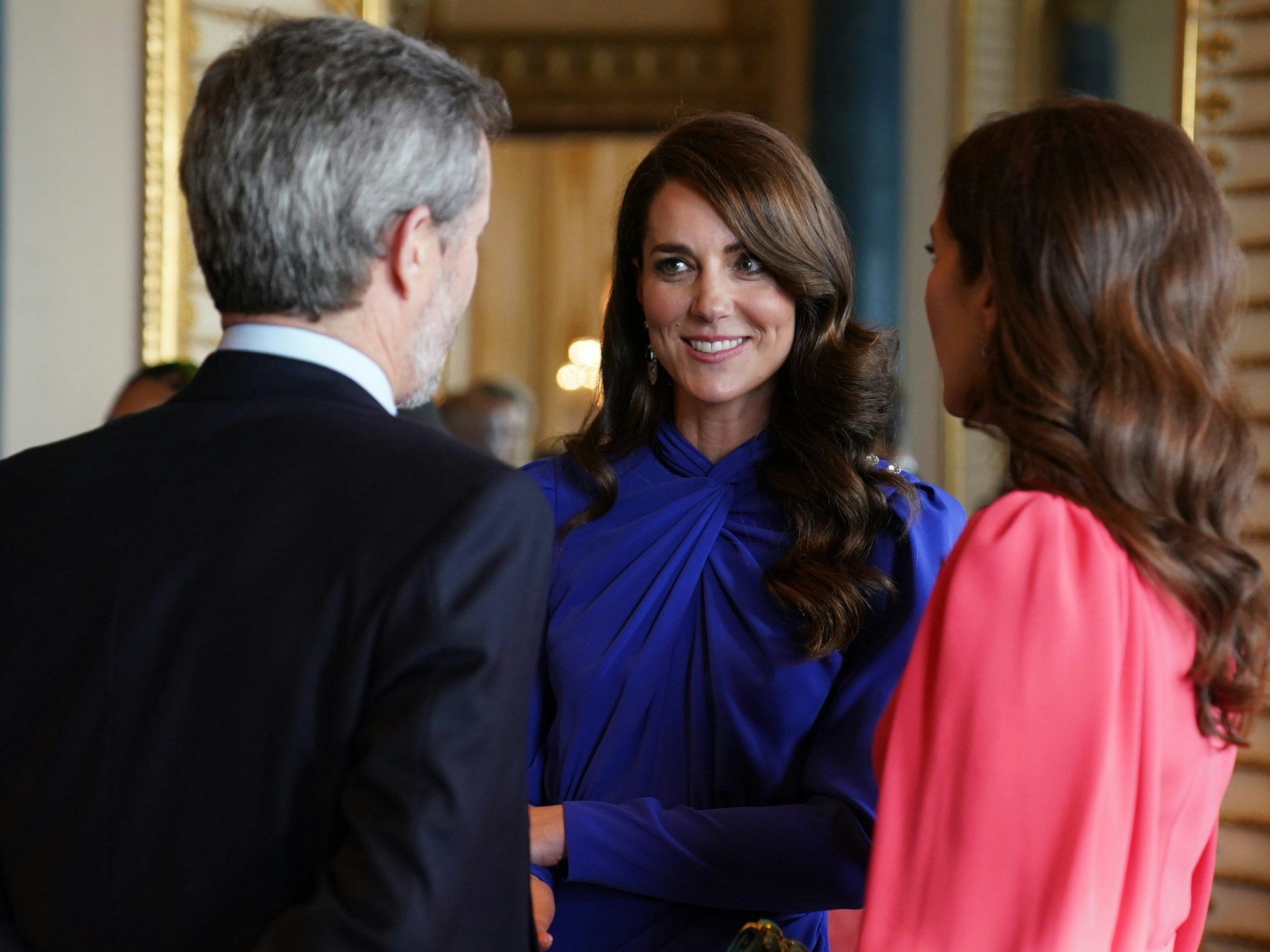 Kate (m), Prinzessin von Wales, spricht mit Mary (r), Kronprinzessin von Dänemark und Frederik, Kronprinz von Dänemark, während eines Empfangs im Buckingham Palace für ausländische Gäste, die an der Krönung von König Charles III. teilnehmen.