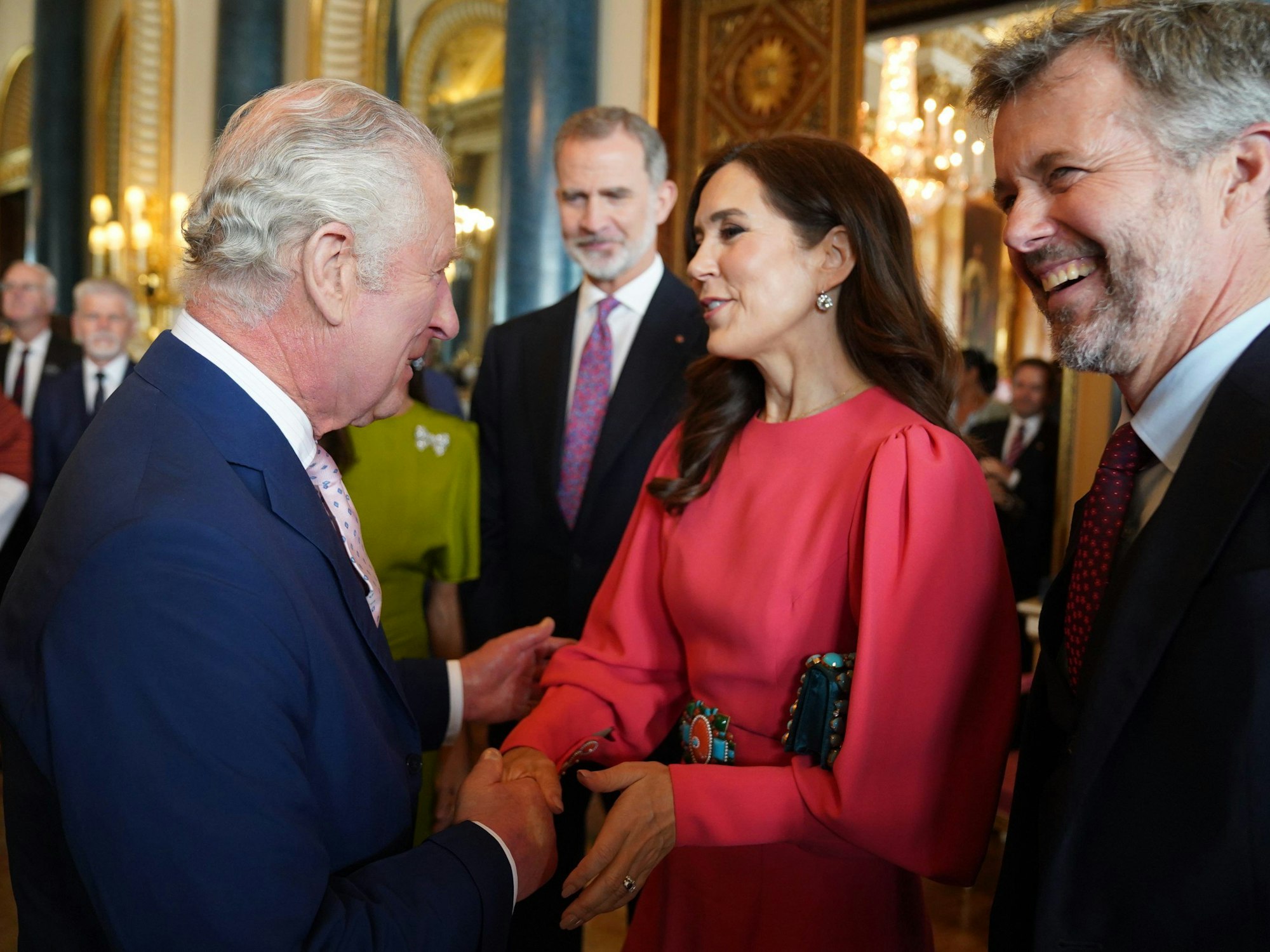 König Charles III. (l) von Großbritannien begrüßt Mary (M), Kronprinzessin von Dänemark, und Frederik, Kronprinz von Dänemark, während eines Empfangs im Buckingham Palace für ausländische Gäste, die an seiner Krönung teilnehmen.
