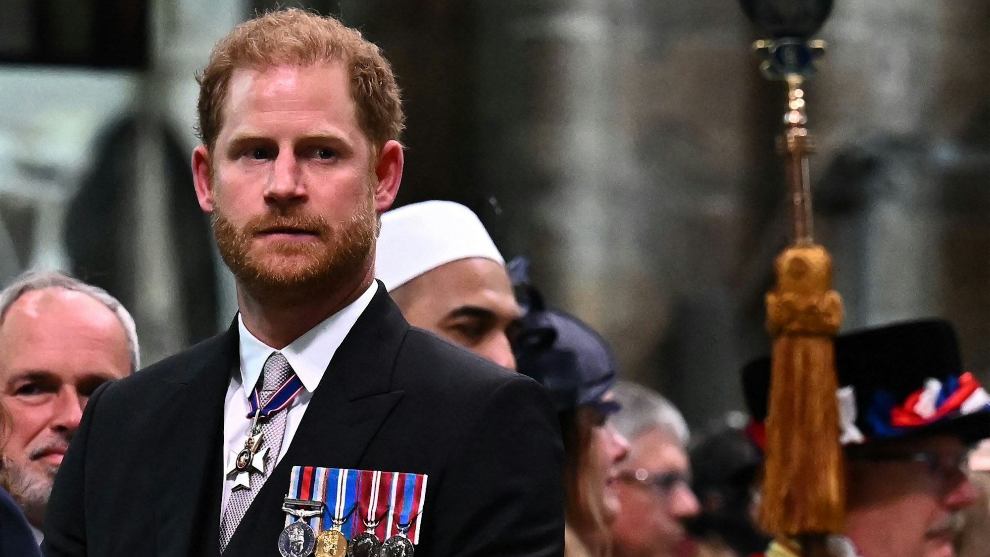 Der britische Prinz Harry, Herzog von Sussex, beobachtet, wie der britische König Charles III. am 6. Mai 2023 nach der Krönungszeremonie die Westminster Abbey im Zentrum von London verlässt.