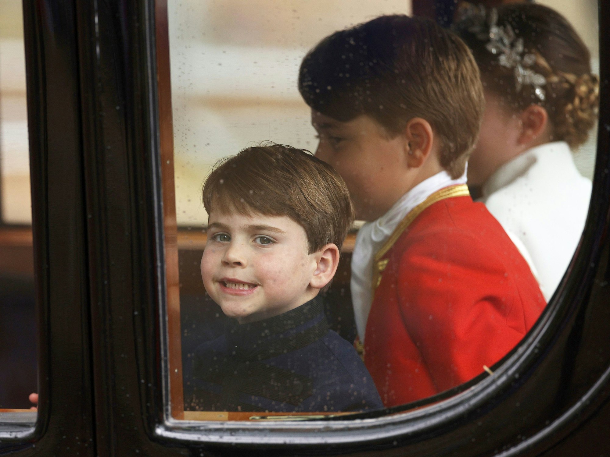 Prinz Louis, Ehrenpage Prinz George und Prinzessin Charlotte von Wales sitzen nach der Krönung von König Charles III. und Königin Camilla in einer Kutsche.