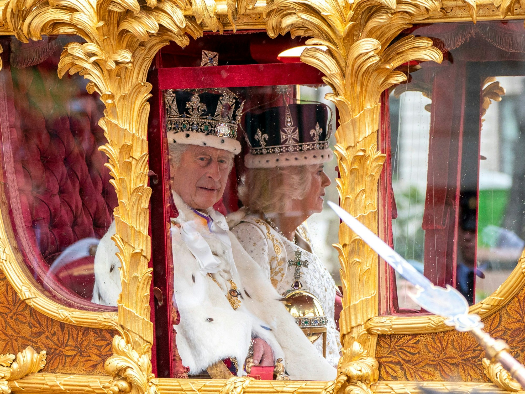 König Charles III. und Königin Camilla in der goldenen Staatskutsche, gezogen von acht Windsor Greys, während des Krönungsumzugs über den Parliament Square zum Buckingham Palace nach der Krönungszeremonie in der Westminster Abbey am Samstag, 6. Mai 2023.