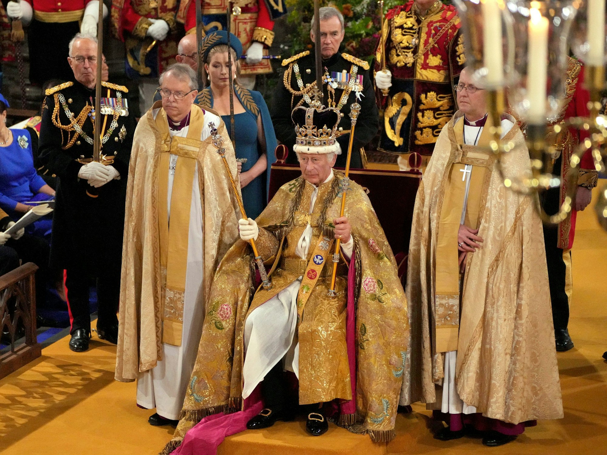 König Charles III. sitzt mit der Edwardskrone und den beiden Zepter auf dem Thron, nachdem er von Justin Welby, Erzbischof von Canterbury, in der Westminster Abbey gekrönt wurde.
