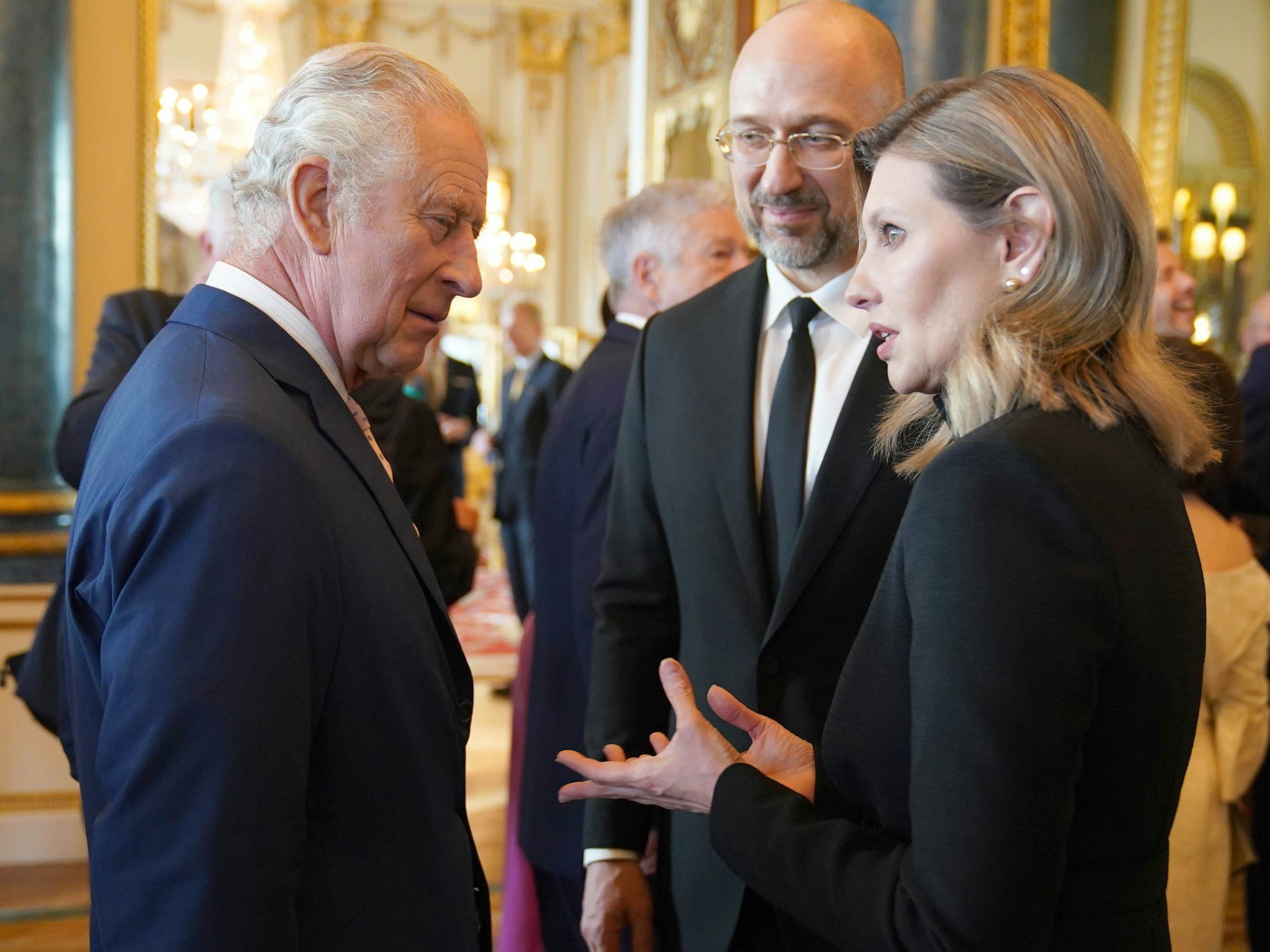 König Charles III. (l) von Großbritannien spricht mit Olena Zelenska (r), First Lady der Ukraine, und Denys Schmyhal, Ministerpräsident der Ukraine, während eines Empfangs im Buckingham Palace für ausländische Gäste, die an seiner Krönung teilnehmen.