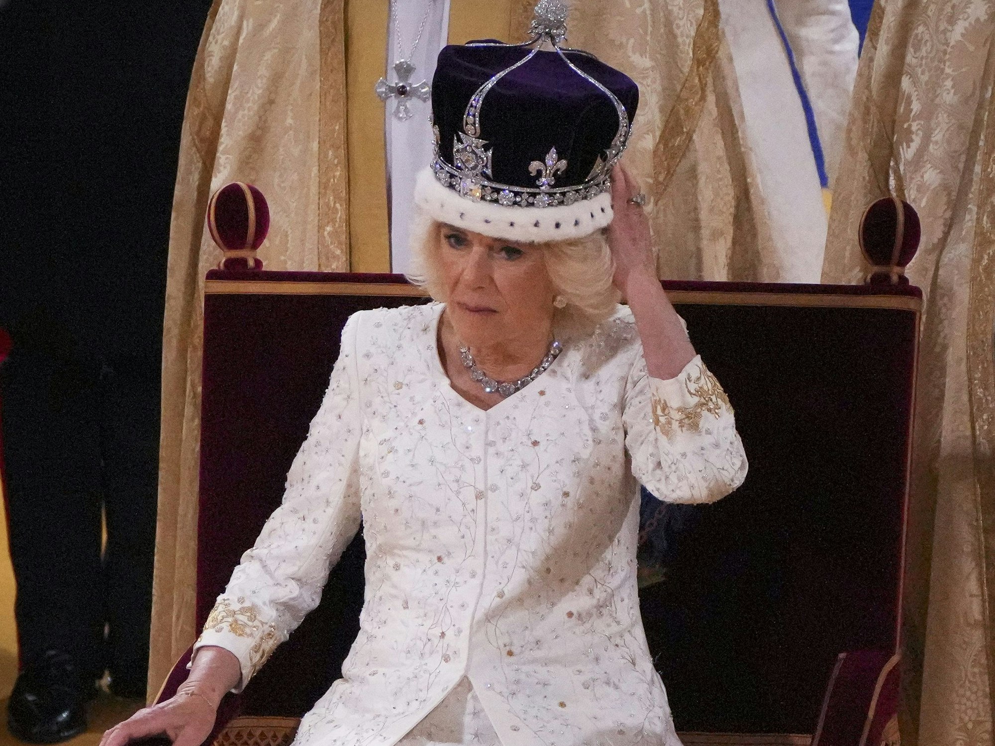 Königin Camilla hält nach der Krönung ihre Hand an die Krone von Queen Mary während der Krönungszeremonie in der Westminster Abbey.