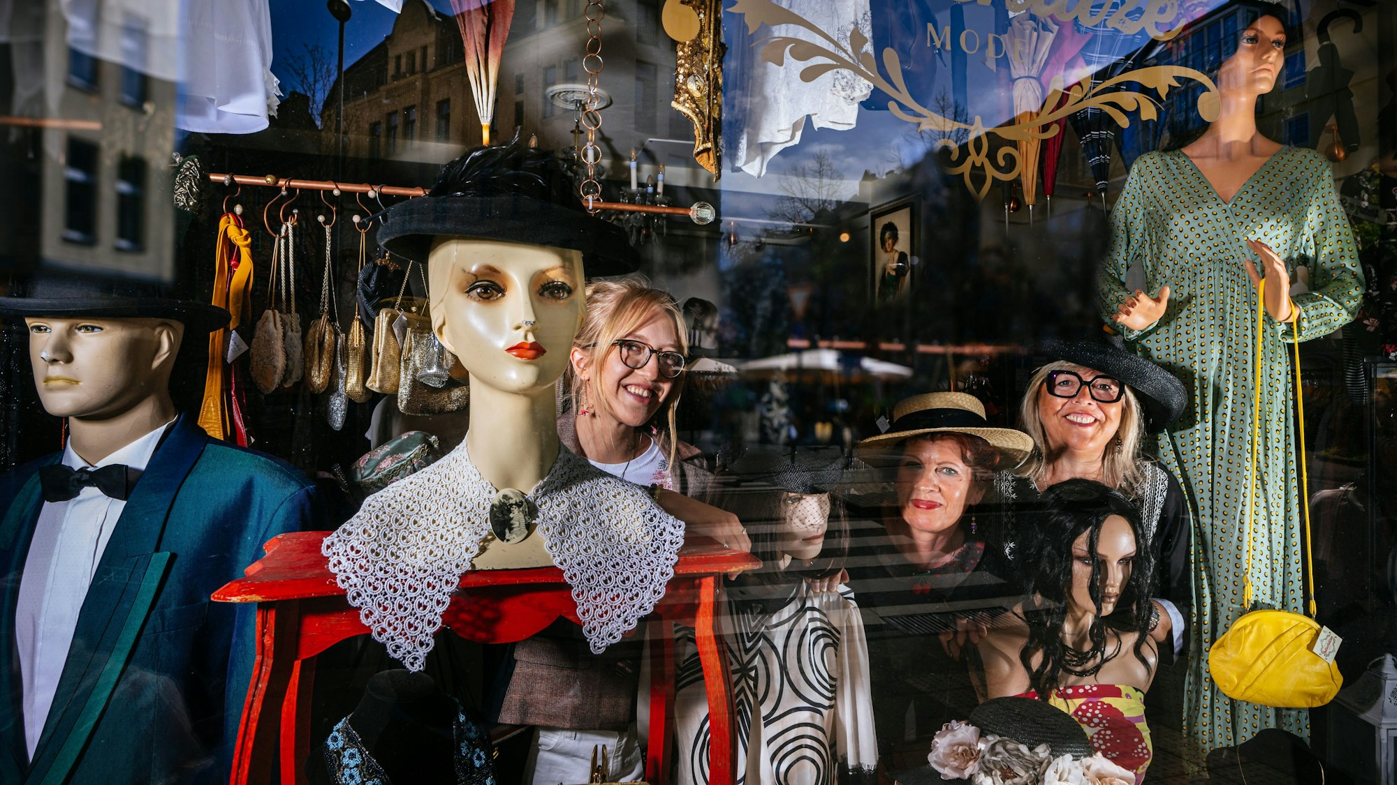 Inga Weishaupt, Angelika Stöckle und Tina Weishaupt (v.l.) schauen lächelnd durch das dekorierte Schaufenster von "Zeitschätze".