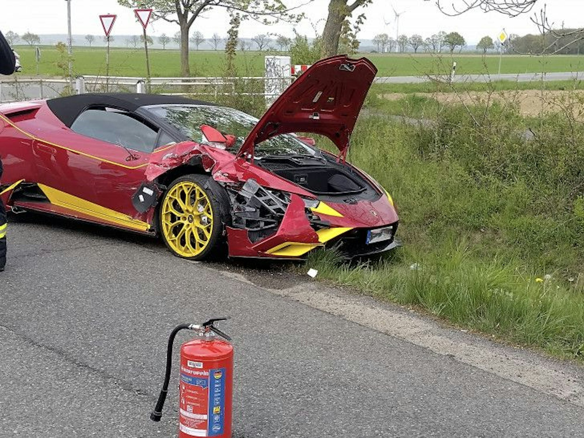 Ein demolierter, roter Lamborghini steht nach einem Unfall in Goslar am Straßenrand.