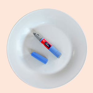 Ein Semaglutid-Pen liegt auf einem ansonsten leeren Teller.