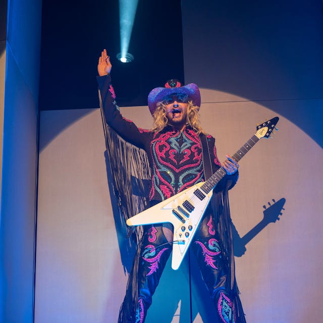 Bill Kaulitz mit Cowboyhut und Metalgitarre auf der Bühne im Kölner E-Werk.