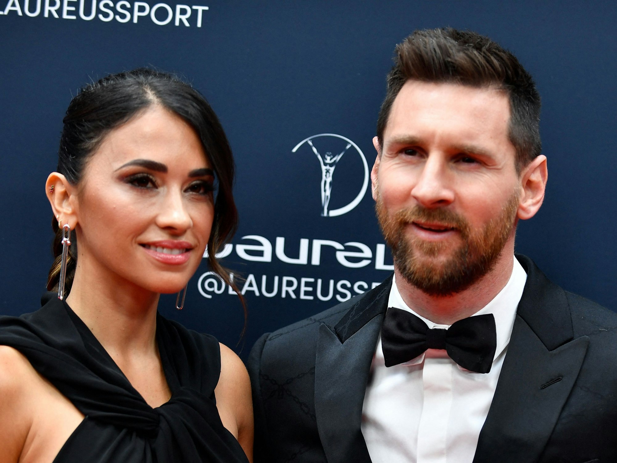 Lionel Messi steht mit seiner Frau Antonela Roccuzzo auf dem roten Teppich in Paris und posiert für die Kameras.