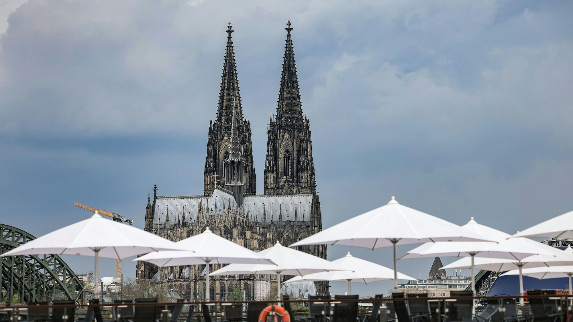 Wolken ziehen hinter dem Dom in Köln auf. Die Temperaturen gehen zum Wochenanfang zurück.