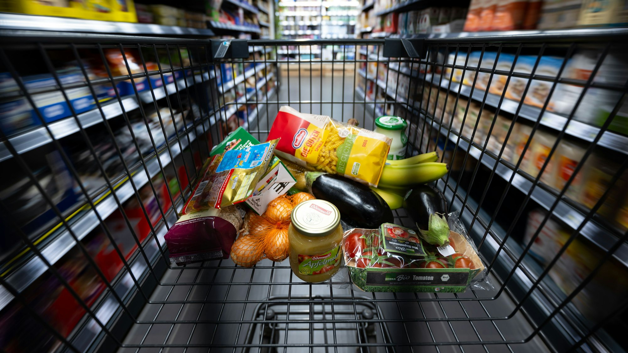 Verschiedene Lebensmittel liegen in einem Supermarkt in einem Einkaufswagen. Maggi ruft Brühen im Glas zurück.