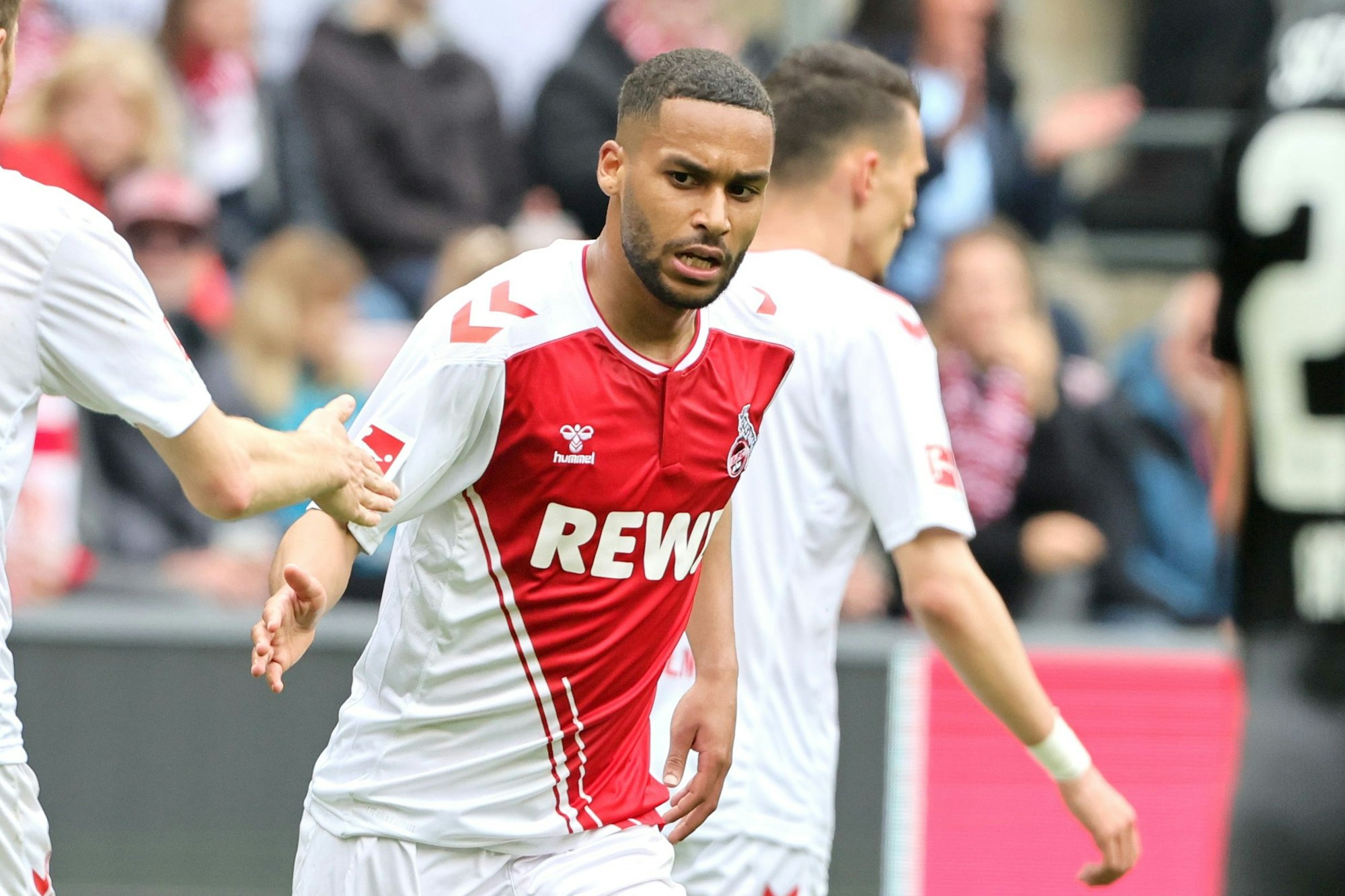 Kölns Linton Maina (r.) klatscht im Bundesliga-Heimspiel gegen Freiburg mit Timo Hübers ab.