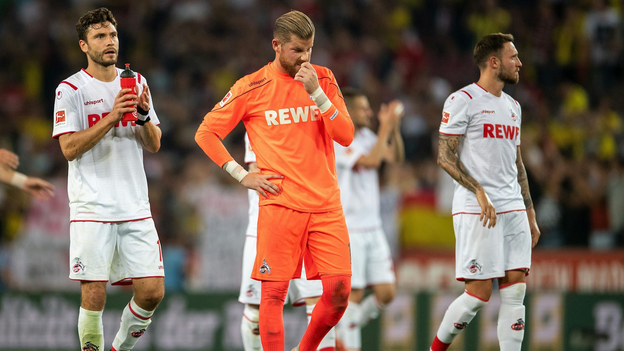 Kölns Jonas Hector (l-r), Torwart Timo Horn und Marco Höger gehen nach der Partie gegen Dortmund vom Rasen.