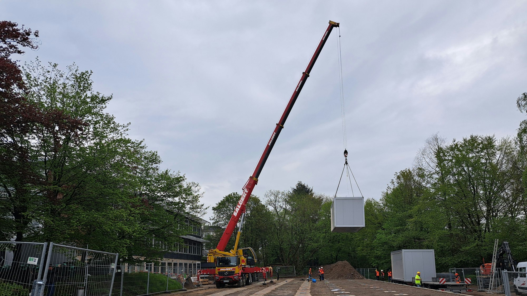 Ein Kran hebt einen Container hoch, der als Ausweichquartier für die Hermann-Voss-Realschule fungieren soll.