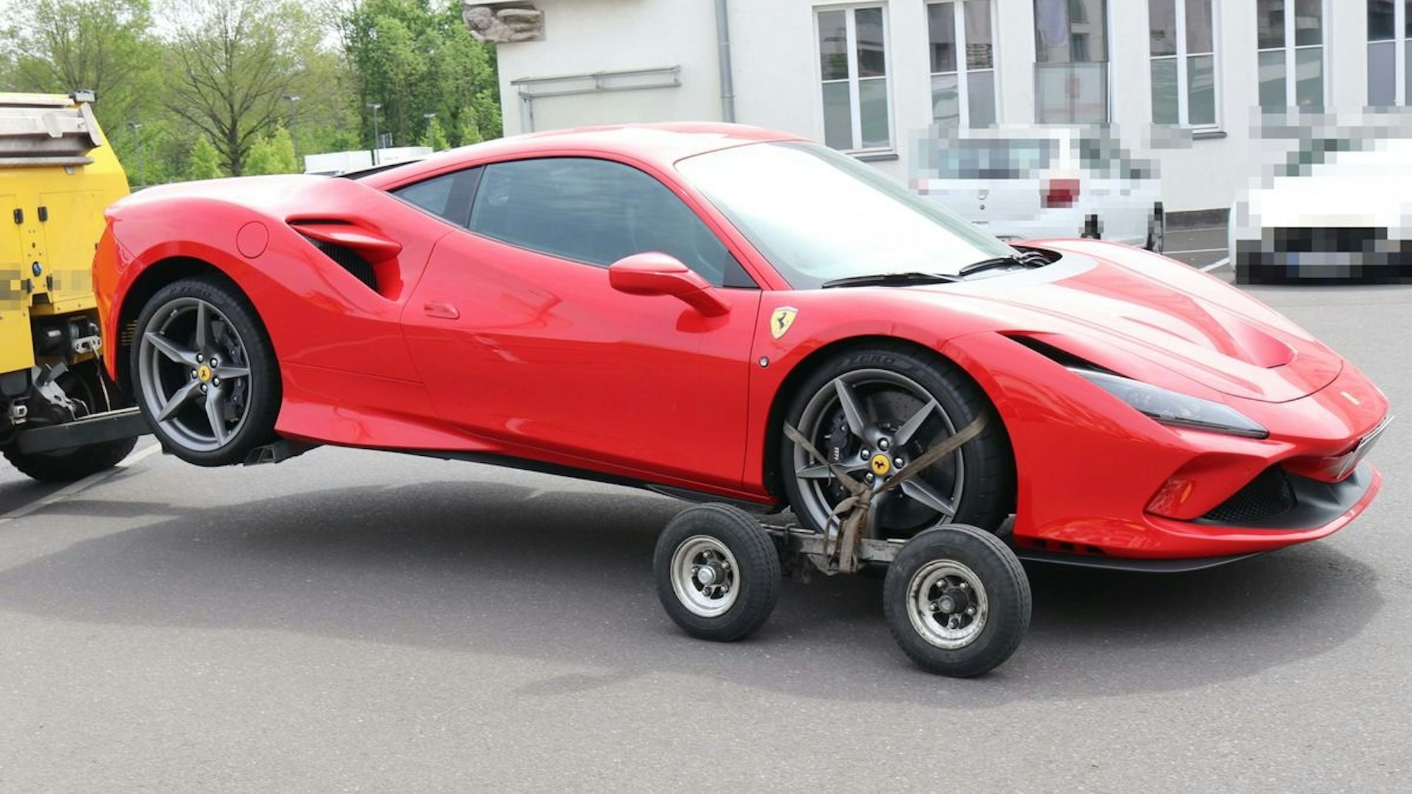 Das Bild zeigt einen roten Ferrari, der abgeschleppt wird.