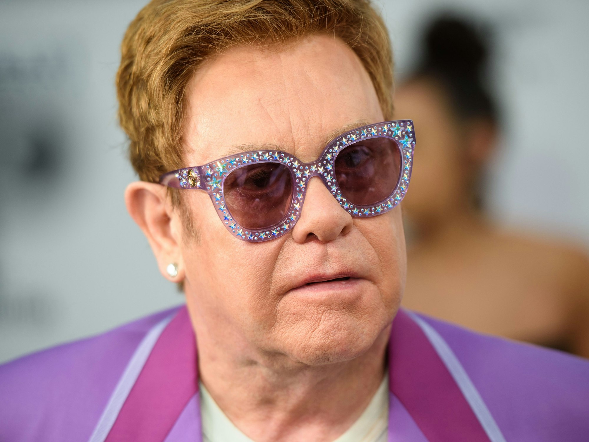 Elton John trägt eine pinke, auffällige Sonnenbrille