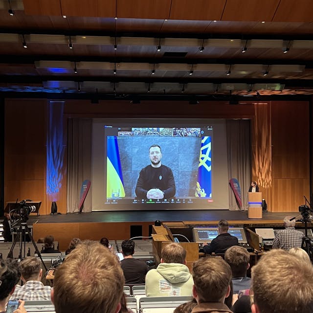 Wolodymyr Selenskyj ist auf einem Bildschirm in einem Hörsaal zu sehen.