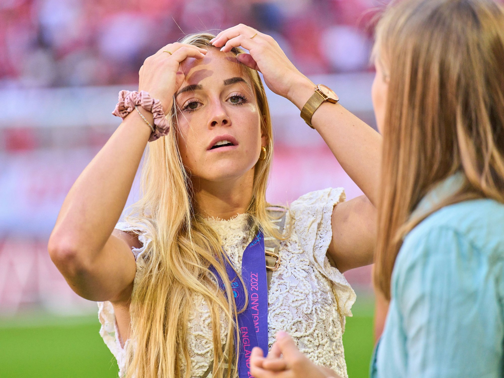 Giulia Gwinn fährt sich bei einer Ehrung der Münchner EM-Teilnehmerinnen vor dem Spiel Bayern gegen Wolfsburg durch das Haar.