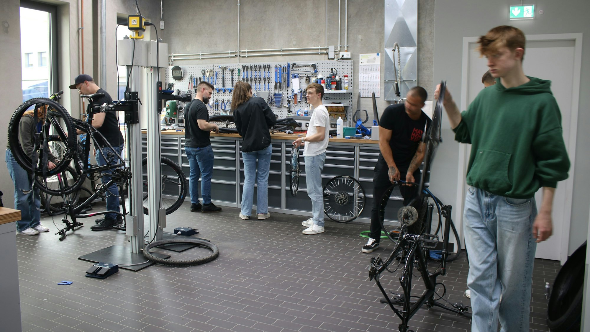 Mehrere Schüler schrauben in einer Werkstatt an Fahrrädern.