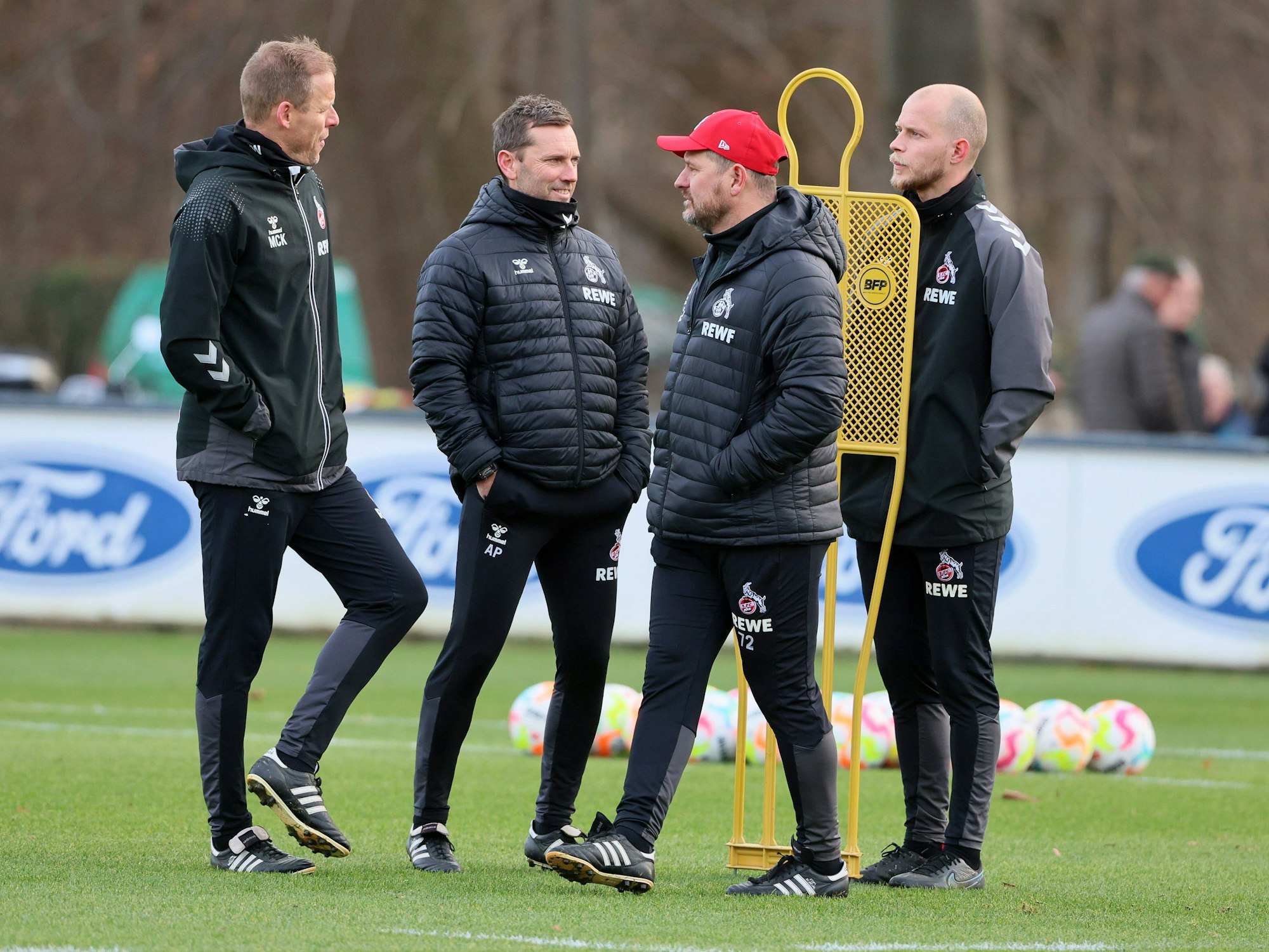 Steffen Baumgart und seine Co-Trainer stehen auf dem Trainingsplatz.