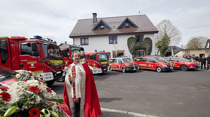 Pater Paul Cyrus aus Steinfeld steht vor den acht neuen Fahrzeugen, die er einweihte.