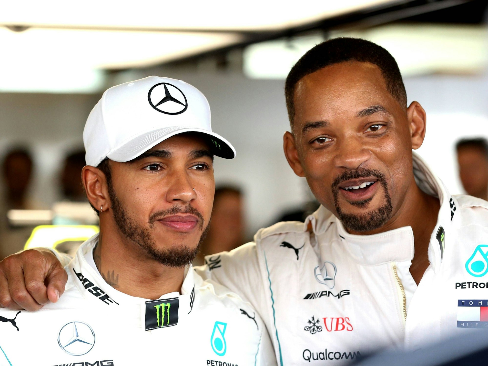 Lewis Hamilton (l.) und Will Smith stehen Arm in Arm beim Großen Preis von Abu Dhabi in der Boxengasse.