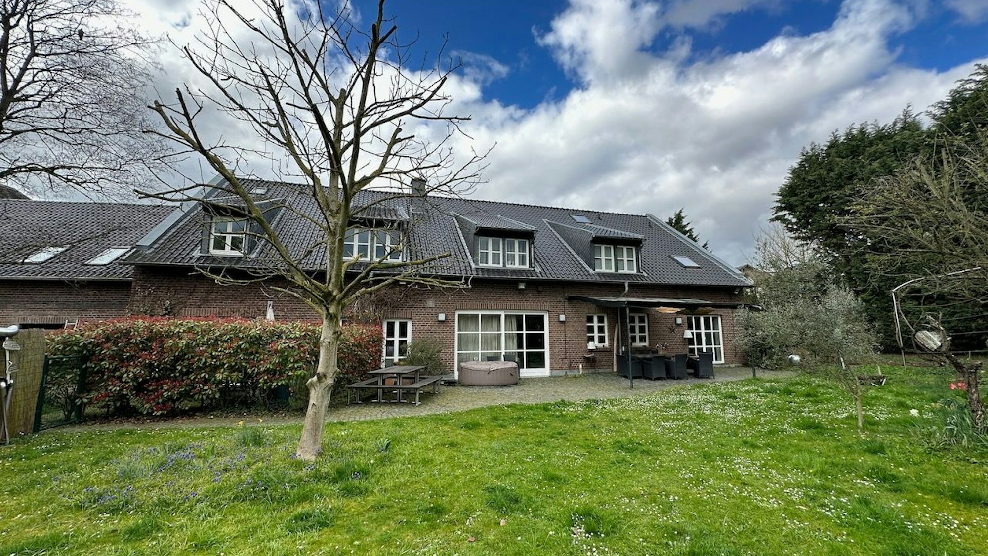 Ein großes Wohnhaus mit Garten und Baumbestand ist zu sehen.