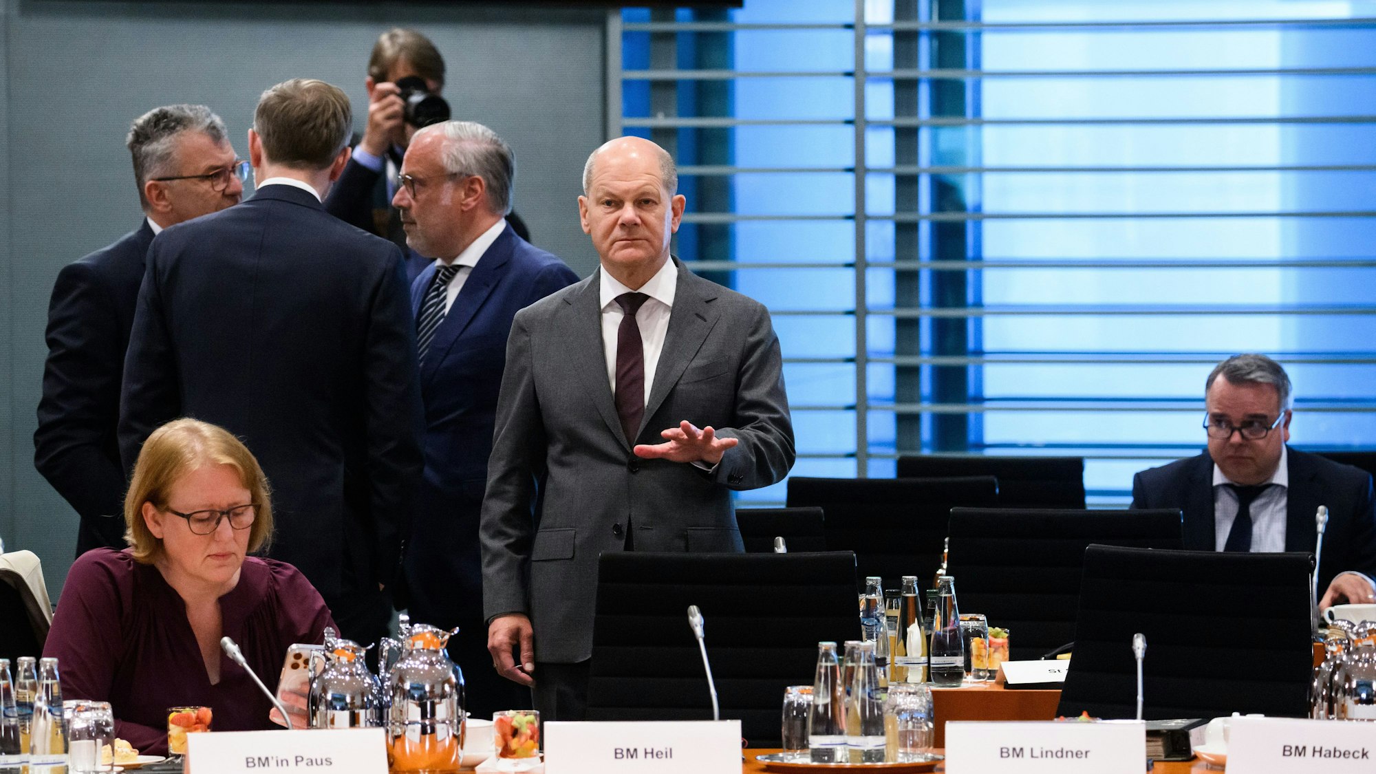 Berlin: Bundeskanzler Olaf Scholz (SPD) steht zu Beginn des Bund-Länder-Gipfels im Bundeskanzleramt. Neben ihm sitzt Lisa Paus (Bündnis 90/Die Grünen), Bundesministerin für Familie, Senioren, Frauen und Jugend.