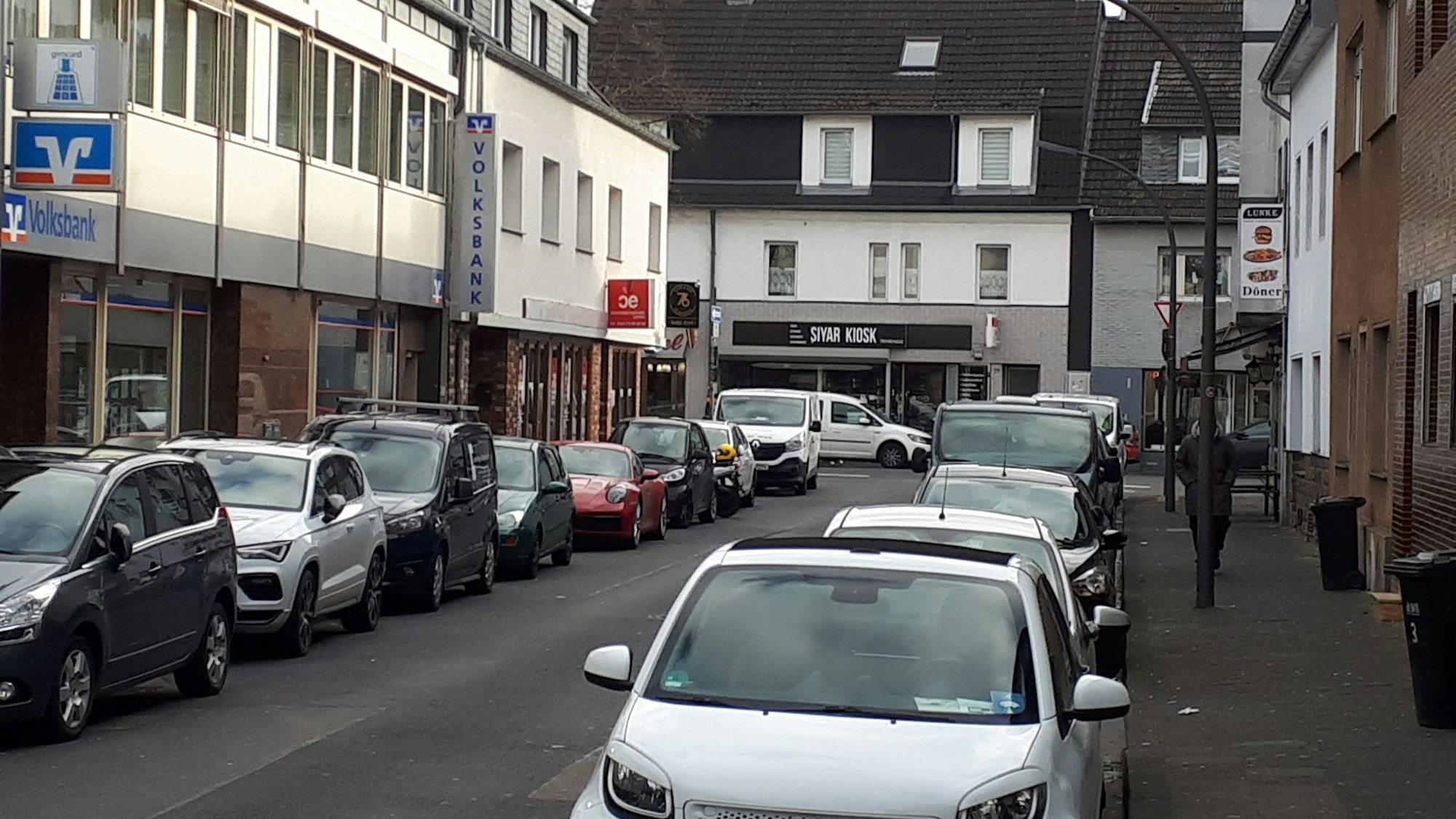 Blich in eine Straße mit beidseitig parkenden Autos