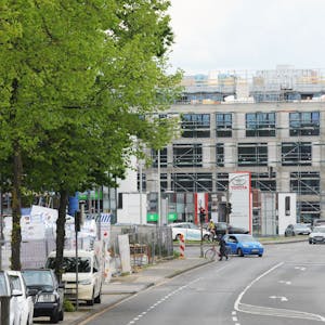 Das neue Neobel Stadtquartier in Frechen ist aktuell noch eine Baustelle. Eine Straße mit fahrenden Autos ist zu sehen, rechts im Bild ist eine Shell-Tankstelle.