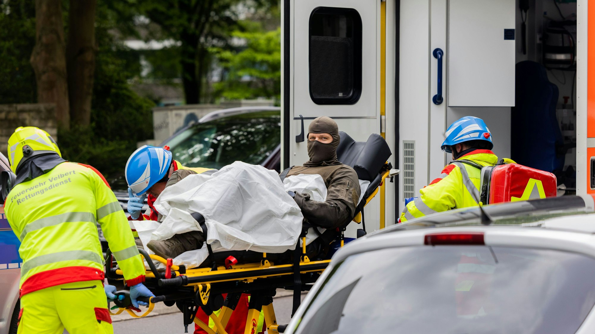 Ein verletzter Polizeibeamter wird nach einer Explosion in einem Hochhaus in Ratingen am 11. Mai in einen Krankenwagen gebracht.