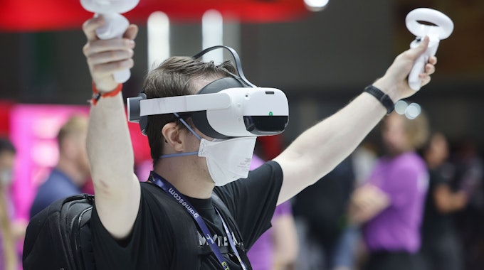 Ein Messebesucher testet mit einer VR-Brille (Virtual Reality) ein Computerspiel.&nbsp;