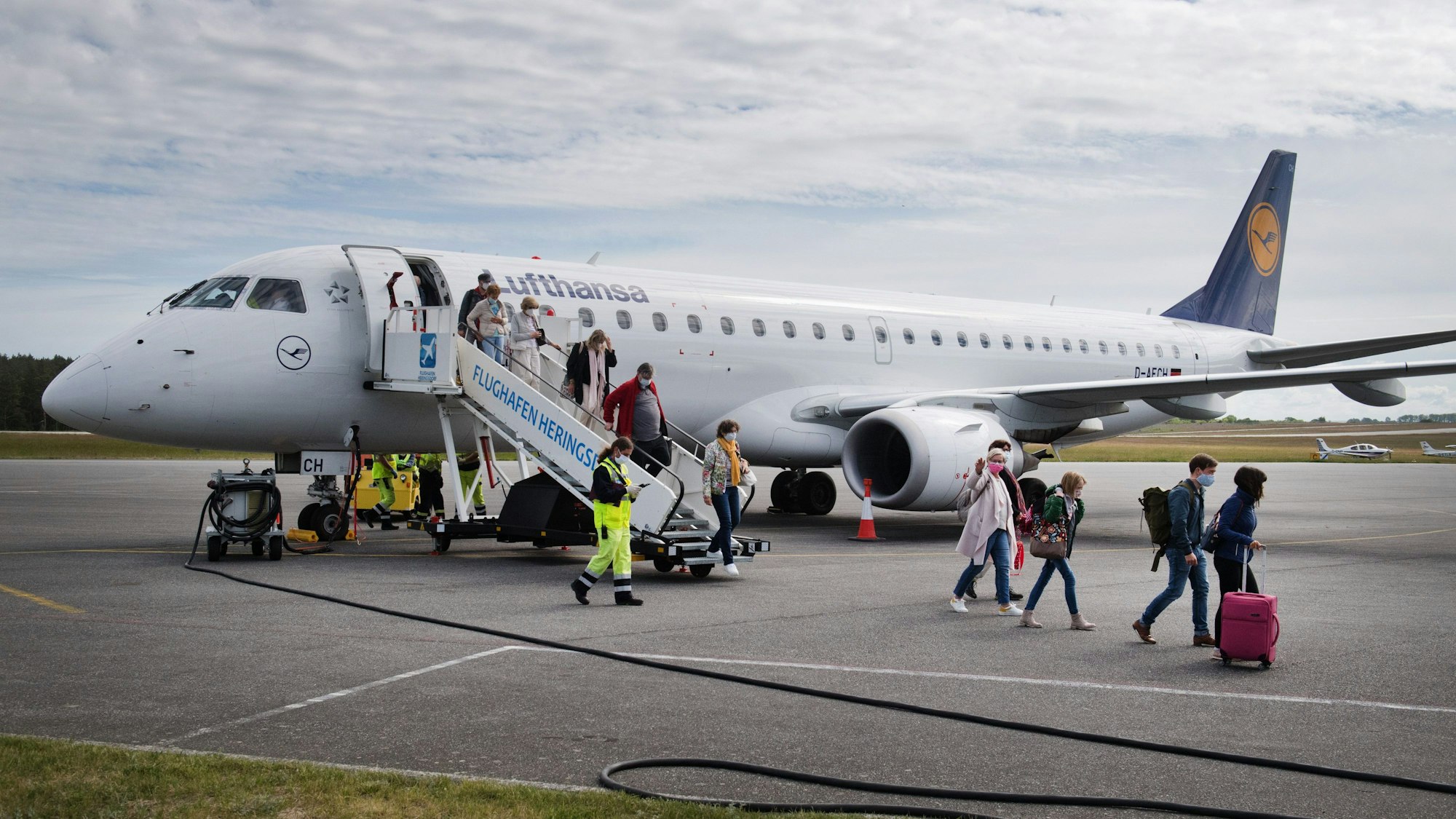 Menschen steigen aus einer Lufthansa-Maschine am Flughafen in Heringsdorf.