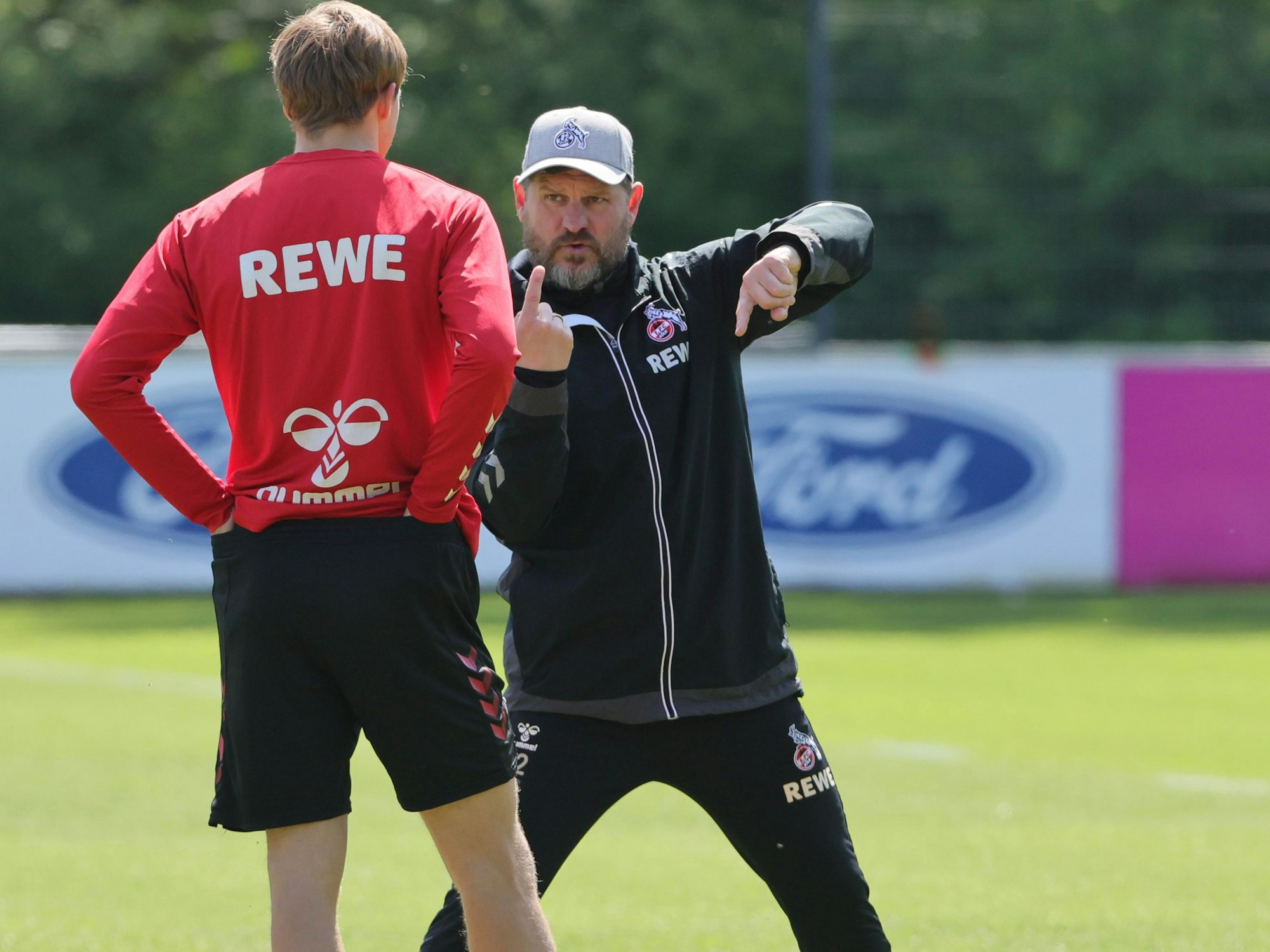 Steffen Baumgart erklärt Timo Hübers etwas im Training.