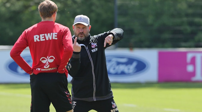 Steffen Baumgart erklärt Timo Hübers etwas im Training.