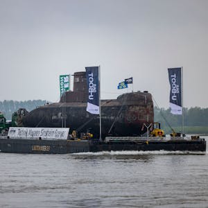 Das U-Boot auf einem Schwimmponton passiert auf dem Rhein den Ort Bimmen.