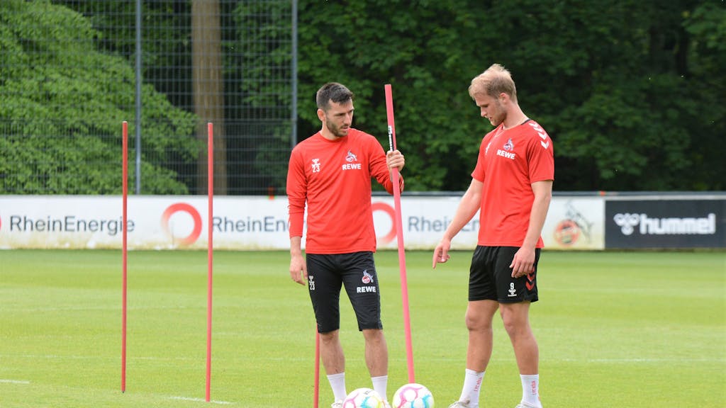 Sebastian Andersson und Sargis Adamyan stehen beim Training des 1. FC Köln auf dem Rasen.