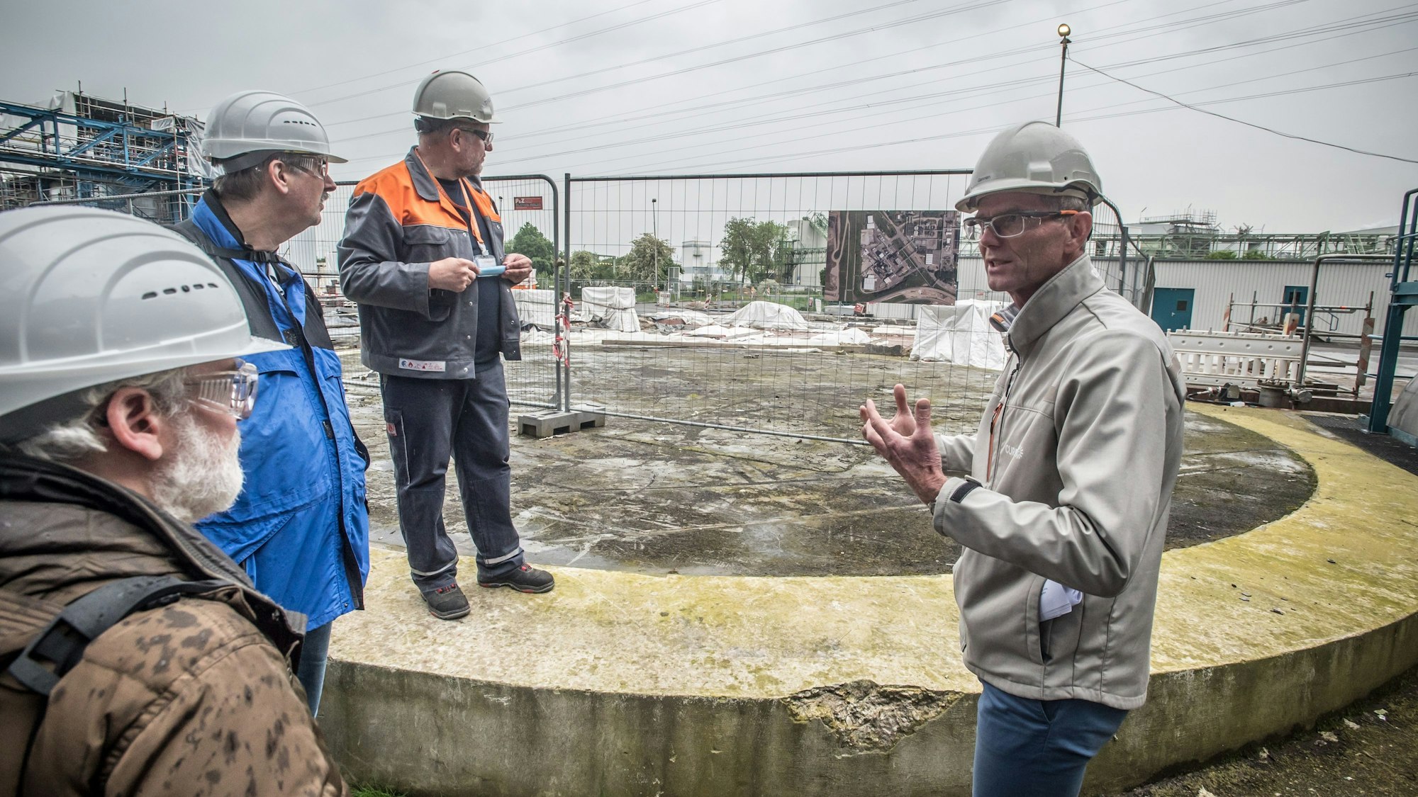 Currentas Technik-Chef Hans Gennen steht mit Mitgliedern des Begleitkreises am Ort des Kesselzerknalls und der Explosion im ehemaligen Tanklager der Sondermüllverbrennungsanlage in Bürrig.