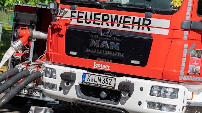 Ein Feuerwehrauto der Kölner Feuerwehr mit angeschlossenen Schläuchen.