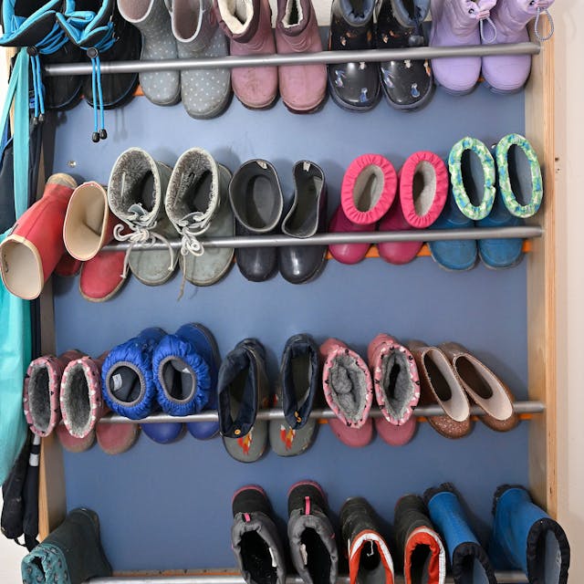 Schuhe und Stiefel hängen an einer Garderobe.&nbsp;