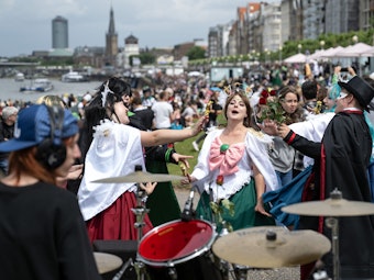 21.05.2022, Nordrhein-Westfalen, Düsseldorf: Verkleidete Jugendliche tanzen am Rheinufer beim Japan-Tag zu Schlagzeugklängen.