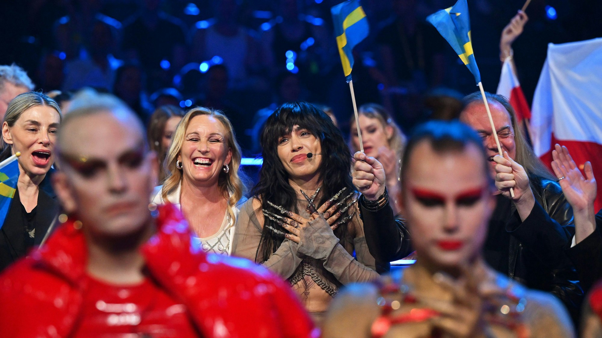 14.05.2023, Großbritannien, Liverpool: Loreen (M) aus Schweden reagiert während der Abstimmung beim Finale des 67. Eurovision Song Contest (ESC) in der M&S Bank Arena. Im Vordergrund sind Lord Of The Lost aus Deutschland zu sehen. Foto: Peter Kneffel/dpa +++ dpa-Bildfunk +++