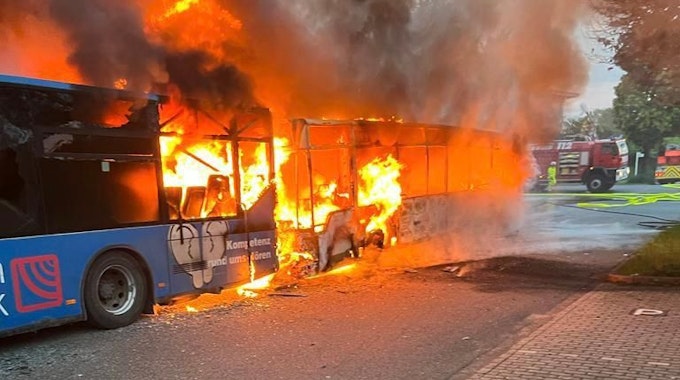 Einsatzkräfte der Feuerwehr löschen am Samstag, 13. Mai 2023, zwei brennende Reisebusse bei einer Lagerhalle in Alsdorf-Schaufenberg nahe Aachen.