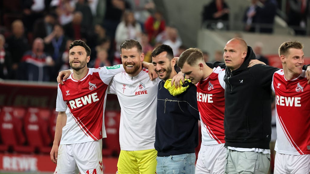 Die Profis des 1. FC Köln stehen Arm in Arm vor der Südkurve.