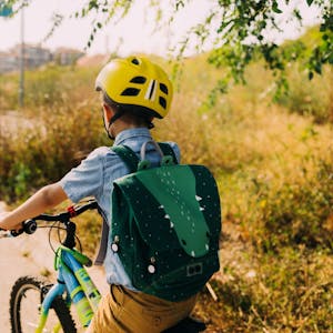 Ein Junge fährt mit dem Rad zur Schule.