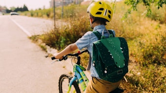Ein Junge fährt mit dem Rad zur Schule.