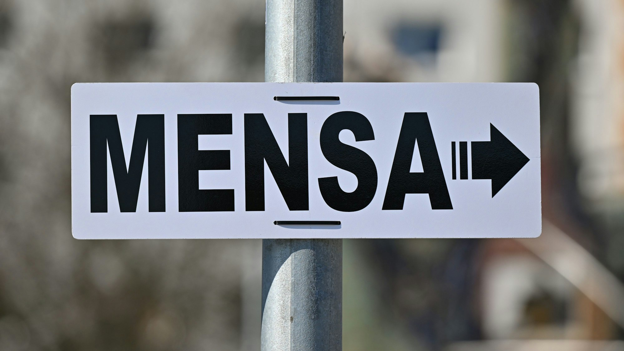Der Mensen-Betrieb zählt zu den Aufgaben der Studierendenwerke. Zu sehen ist ein weißes Schild, auf dem "Mensa" zu lesen ist, mit einem Pfeil nach rechts.