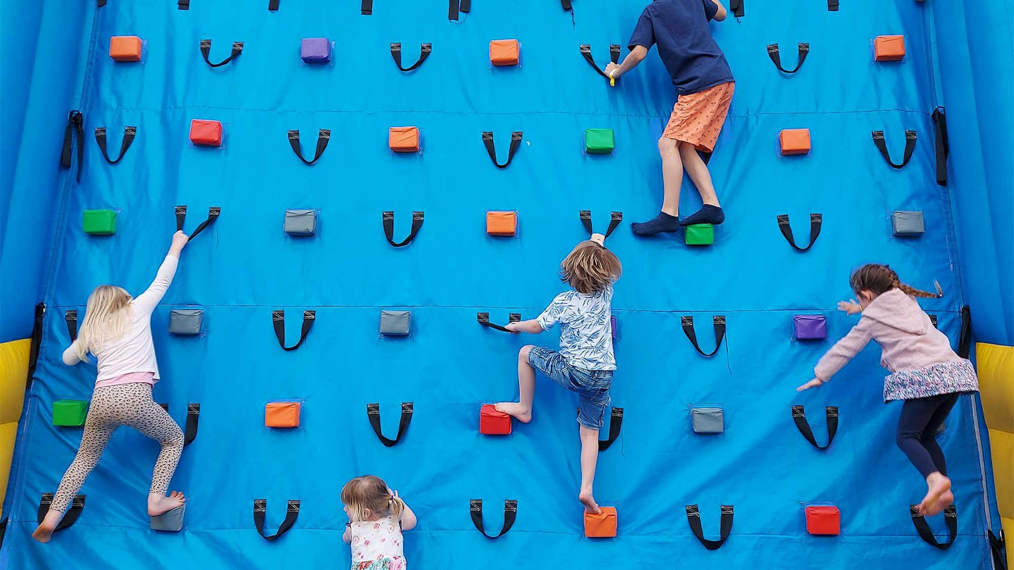 Kinder an einer Kletterwand bei „Jump im Park“.