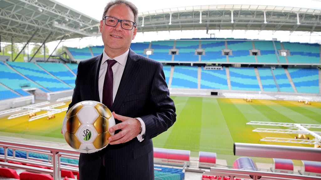 DFB-Vizepräsident Hermann Winkler hält im Stadion einen Ball in den Händen.