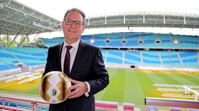 DFB-Vizepräsident Hermann Winkler hält im Stadion einen Ball in den Händen.